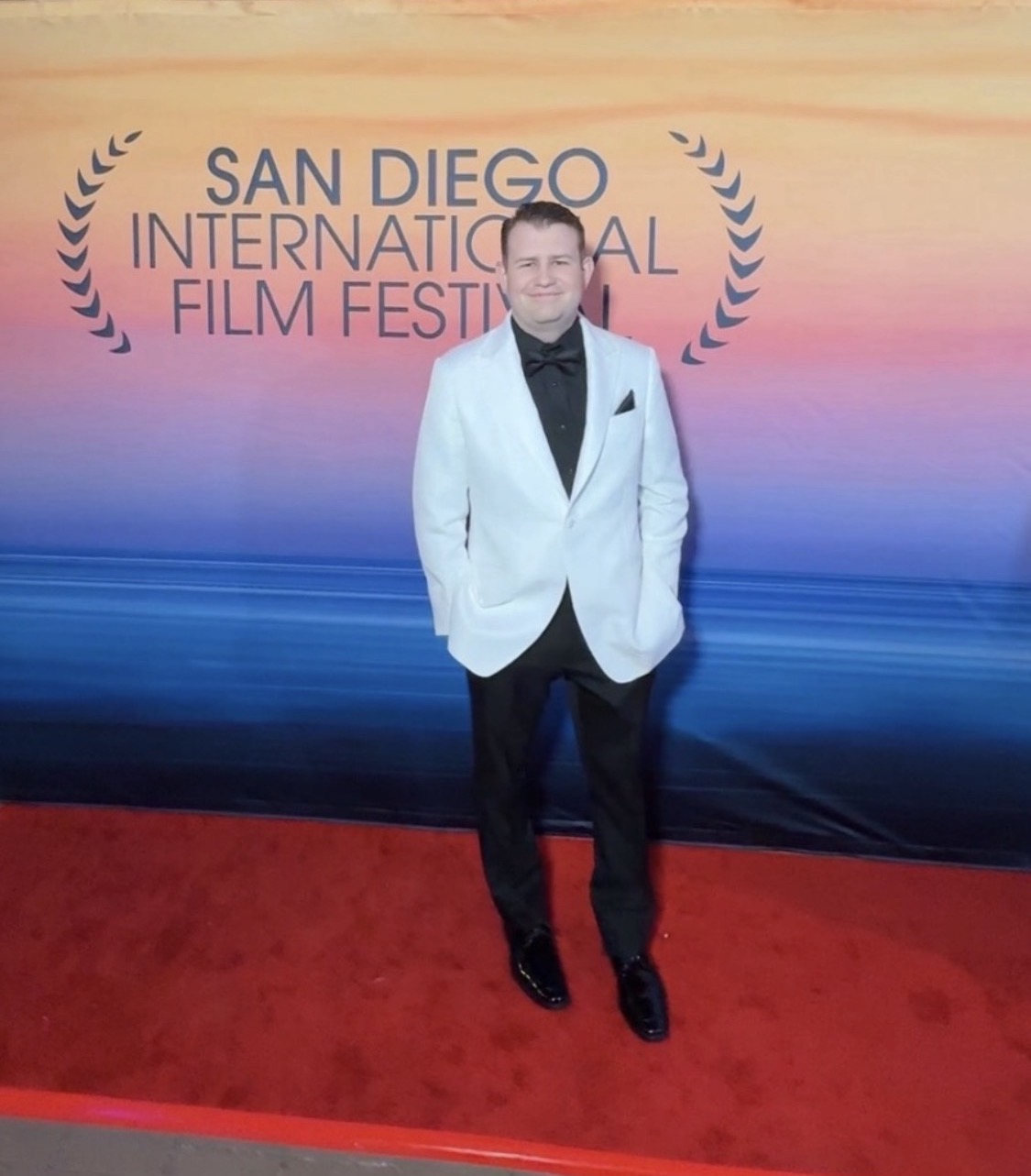 Stephen Lepore in a white tuxedo jacket on the red carpet at the San Diego International Film Festival